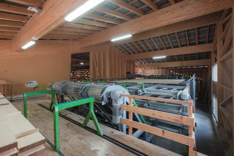 Rundholz-Bearbeitungsanlage in der lichten Brettschichtholz-Halle des Sägewerks
