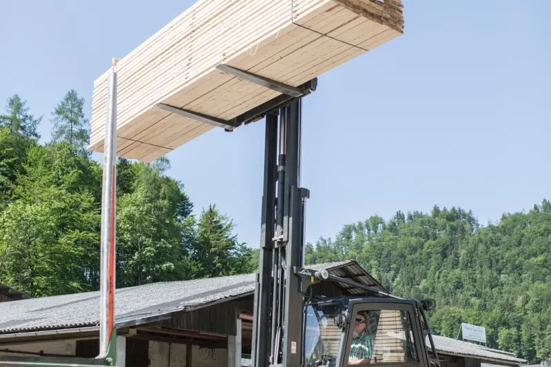 Gabelstapler hebt ein Bündel frisch geschnittener Bretter empor